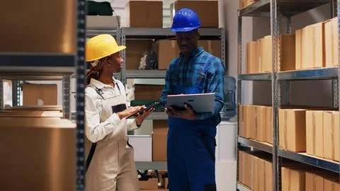 Two depot workers checking merchandise on shelves Stock Photos