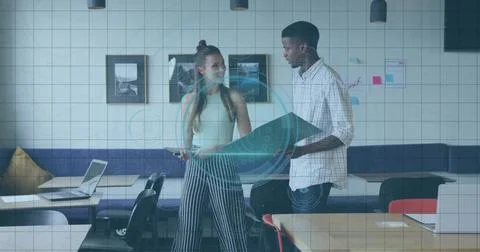 Two designers reviewing data visualization in coworking space, with blueprint 스톡 사진