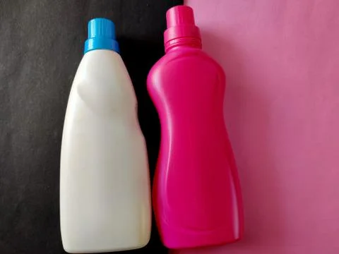 Two detergent plastic bottles in white and pink color isolated on pink and bl Stock Photos