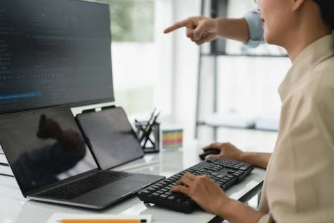 Two developer programmer checking code on multiple monitor while programmin.. Stockfoto's