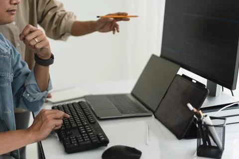 Two developer programmer discussing to checking code on monitor about progr.. Stockfoto's