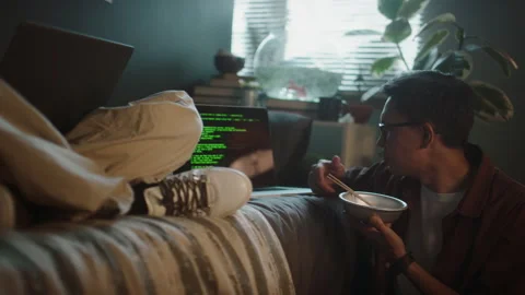 Two Developers Holding Bowls and Eating with Chopsticks while Coding Stock Footage 290873433