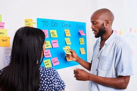Two developers move tickets on scrum board during sprint planning Foto stock