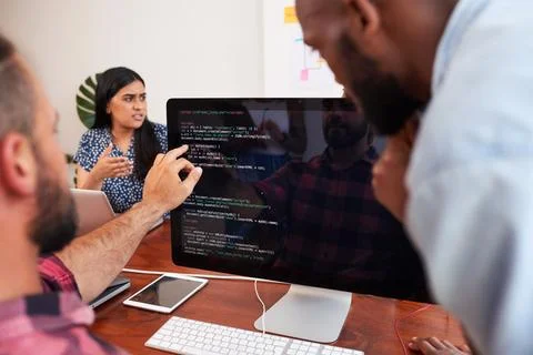 Two developers peer programming together in office, assisting peer review 写真素材
