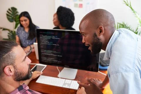 Two developers peer programming together in office, assisting peer review Stock-Fotos