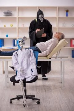 Two devil doctors examining old male patient Stock Photos