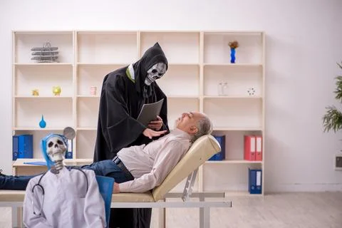 Two devil doctors examining old male patient Stock Photos