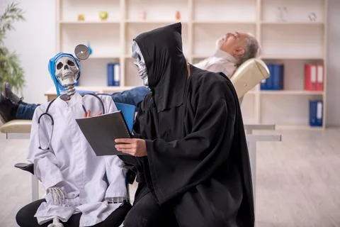 Two devil doctors examining old male patient Foto stock