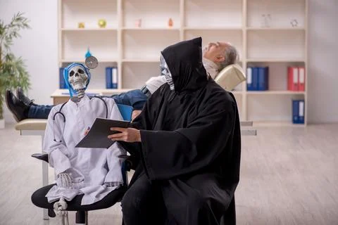 Two devil doctors examining old male patient Foto stock