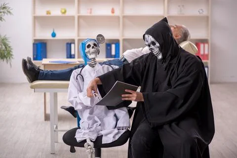 Two devil doctors examining old male patient Foto stock