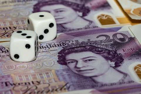 Two Dice Resting on Twenty Pound Note 스톡 사진