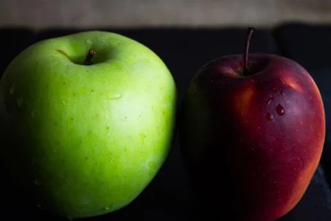Two different apples on slate and rustic background Stock Photos