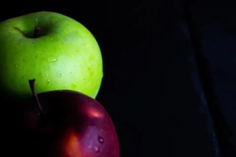 Two different apples on slate and rustic background Stock Photos