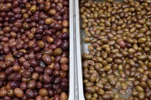 Two different assortment of olives in two stainless containers Stock Photos