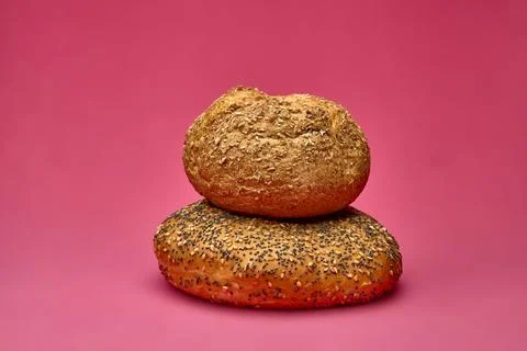 Two different bread rolls stacked on top of each other on pink background Stock-Fotos