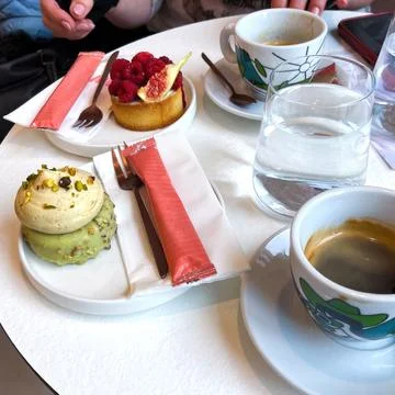 Two different cakes and small cups of coffee on a table in a cafe Stock Photos