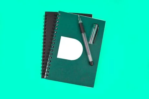 Two different color covered note book and a black color ball point pen arrang Stock Photos