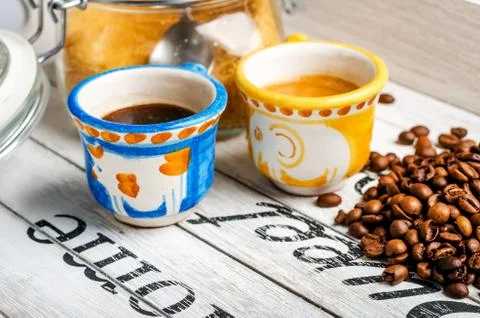 Two different cup of coffee and coffee beans and cane sugar Stock Photos