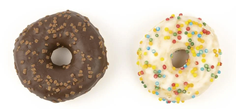 Two different donuts on a light background. The concept of sweet pastries. Stock Photos