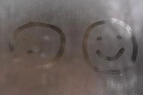 Two different face smile expressions on steamy glass. Foto stock