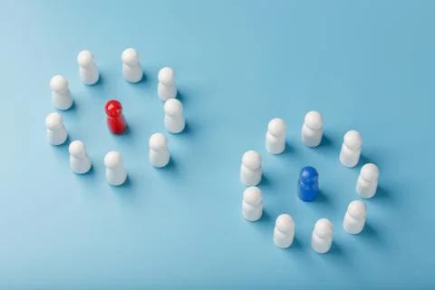 Two different Groups of white people stand around the blue and red leadership 스톡 사진