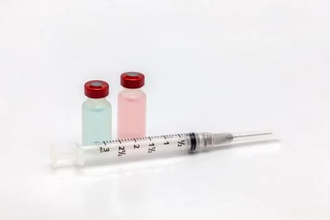 Two different isolated plastic vaccine bottle with different colored liquid a Stock Photos