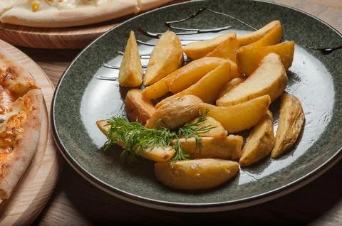 Two different pizzas on the boards and fried potatoes in a plate on the table Stock Photos