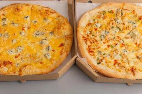 Two different pizzas in a paper box on a gray background. Pizza food delivery Stock Photos