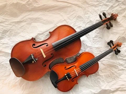 Two different size of violins put on background,warm light tone,blurry light  Stock Photos