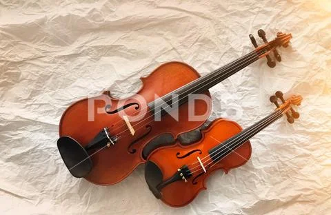Two different size of violins put on background,warm light tone,blurry light Stock Photos