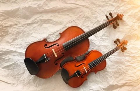 Two different size of violins put on background,warm light tone,blurry light  Stock Photos