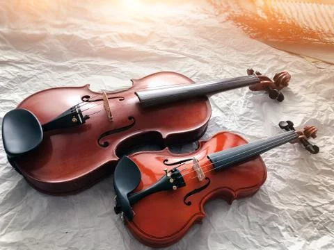 Two different size of violins put on grunge surface ground floor,warm light t Stock-Fotos