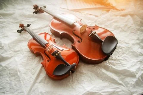 Two different size of violins put on background,warm light tone,blurry light  Stock Photos
