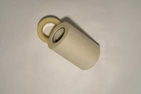 Two different-sized rolls of plasters in white and brown on a white background. Stock Photos