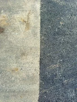 Two different surfaces meet at a clear line. One side is rough concrete, and  Foto stock