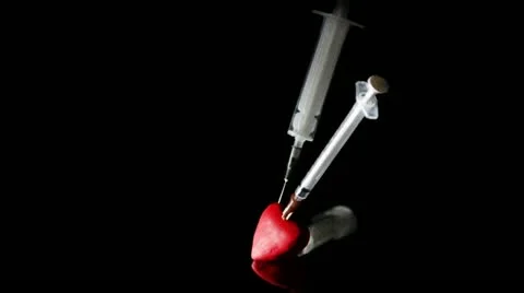 Two different syringe stuck in the red heart Video stock 21434864