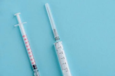 Two different syringes on blue background with copy space Stock Photos
