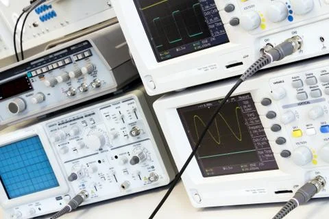 Two digital and one analog oscilloscope on measuring table Fotos Stock