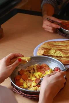 Two diners sharing a hearty breakfast skillet of scrambled eggs Stock Photos