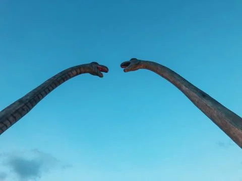 Two dinosaurs against the sky looking at each other. Long neck dinosaurs in C Stock Photos
