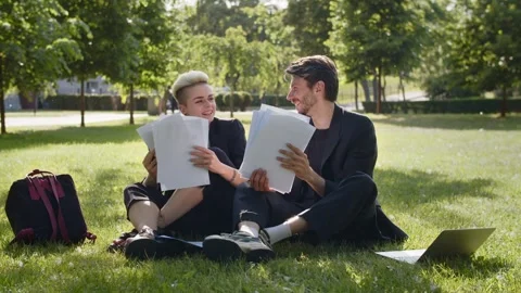 Two directors speaking in green zone about company growth check paper reports Stock Footage 256143610