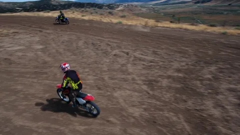 Two dirt bikes chasing each other in the hills, aerial shot, drone Stock Footage 95620182