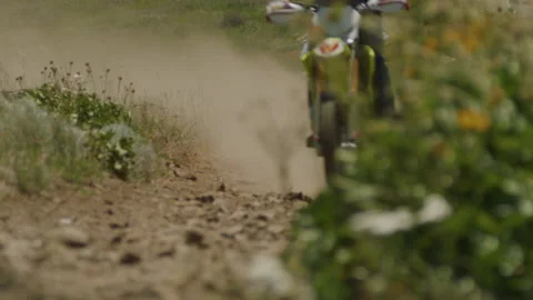 Two dirt bikes ride past camera on a trail - kick up gravel and dust Stock-Footage 232341925