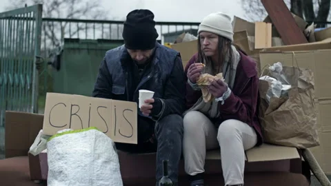 Two dirty and poorly dressed homeless people, a man and a woman, are sitting Stock Footage 237462419