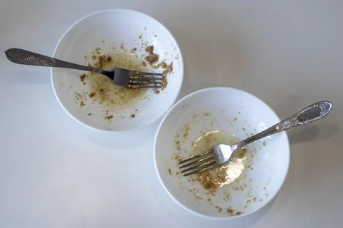 Two dirty empty plates with forks after cod liver, top view Stock Photos