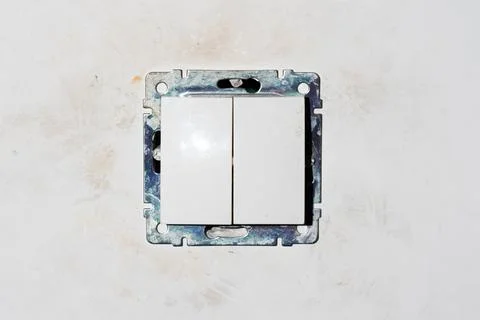 Two dirty light switch plastic buttons without front frame on dirty white gray Stock Photos