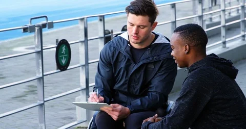 Two disabled athletics discussing over clipboard 4k Stock Footage 96094447