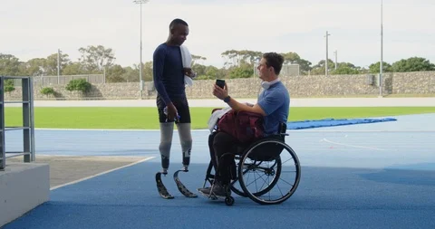Two disabled athletics discussing over mobile phone 4k Stock Footage 96094625