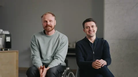 Two disabled men in good mood, man silicone prosthesis and man on wheelchair Stock Footage 228244892
