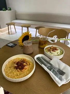 Two dishes with risotto and eggs, iced drinks, and a sunflower Stock Photos